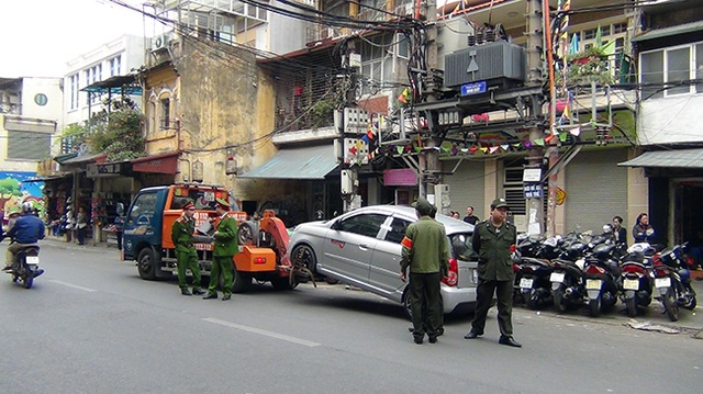 Hà Nội “ra quân” giành lại vỉa hè ở khu trung tâm - 16 Một chiếc ô tô vô chủ đỗ trái phép dưới lòng đường bị cẩu về đồn.