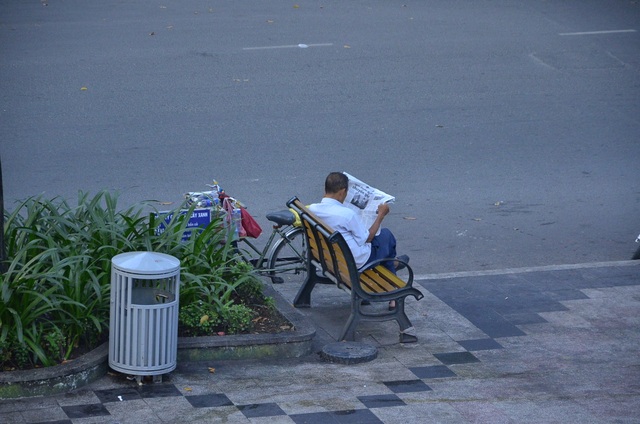Một Sài Gòn không ồn ào, khác lạ trong ngày đầu năm mới - 4 Một người đàn ông thong thả ngồi đọc báo ở hồ Con Rùa