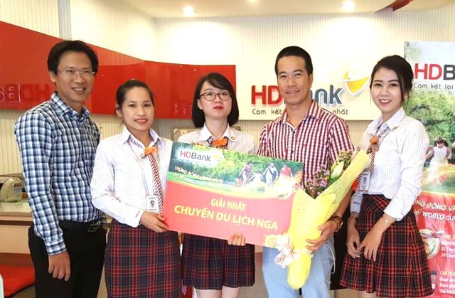 Khách hàng HDBank trúng quả bóng vàng 1 kg - 2 Khách hàng Bạch Minh Khoa (thứ hai từ phải sang) giao dịch tại HDBank Lê Quang Định (TP HCM) nhận giải nhất – chuyến du lịch xem WorldCup 2018 tại Nga trị giá 50 triệu đồng.