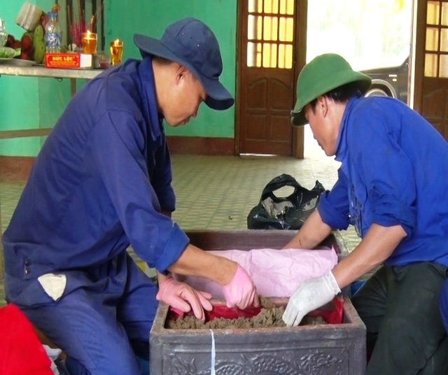 Mở rộng phạm vi tìm kiếm tại khu vực phát hiện nhiều hài cốt - 1 Đội tìm kiếm, quy tập, cất bốc hài cốt (Đội 584) cẩn trọng đưa các mẫu xương, di vật vào tiểu sành (Ảnh: Ph.Q.)