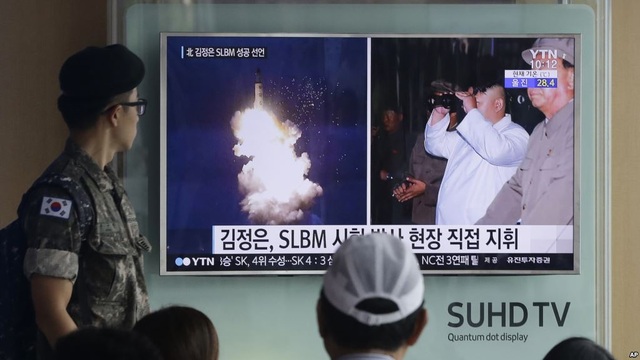 Hầm trú ẩn “phủ kín” Seoul giữa lúc căng thẳng với Triều Tiên - 2 Binh sĩ và người dân Hàn Quốc theo dõi tin tức về vụ phóng tên lửa Triều Tiên qua truyền hình tại nhà ga ở Seoul (Ảnh: AP)