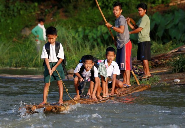 Đường đến trường gian nan của học sinh các nước - 2 Các học sinh đứng trên một bè tự chế để vượt sông khi tới dự lễ khai giảng lớp học mới ở trường tiểu học Casili tại Montalban, Philippines.