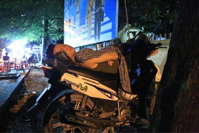Ôm chăn gối ngủ trước cổng trường chờ xin học lớp 1 cho con - 7 Sau nhiều giờ chờ đợi, phụ huynh này chợp mắt trên yên xe máy.