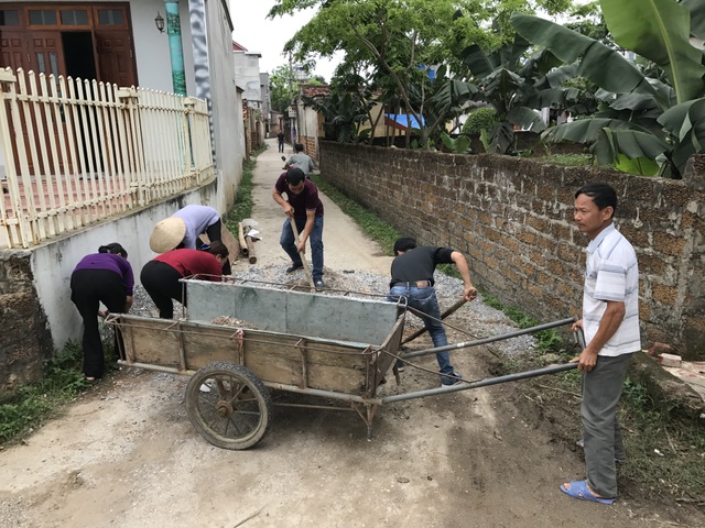 Không truy cứu trách nhiệm hình sự người dân xã Đồng Tâm - 1 Người dân xã Đồng Tâm thu dọn cát đá đổ chắn lối ra vào ngõ xóm