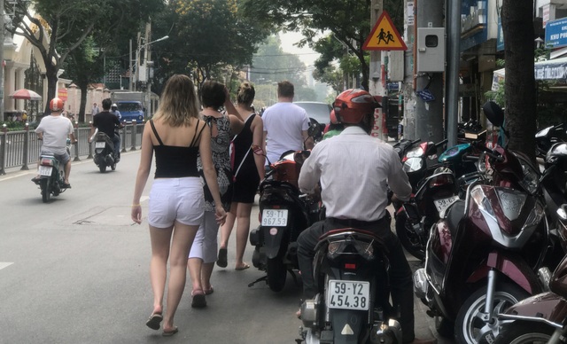 Xe biển xanh, xe máy “nuốt gọn” vỉa hè - 6
Du khách nước ngoài không còn lối đi do vỉa hè bị chiếm dụng trước trụ sở UBND phường 17, quận Bình Thạnh, buộc phải xuống lòng đường tấp nập xe cộ.