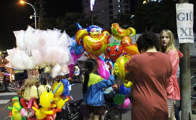 Nha Trang: Du khách nước ngoài hân hoan ra đường đón năm mới Đinh Dậu - 8 Hai mẹ con du khách đang dừng chân bên một điểm bán bong bóng bay. Những bong bóng mang hình con gà được nhiều khách lựa chọn