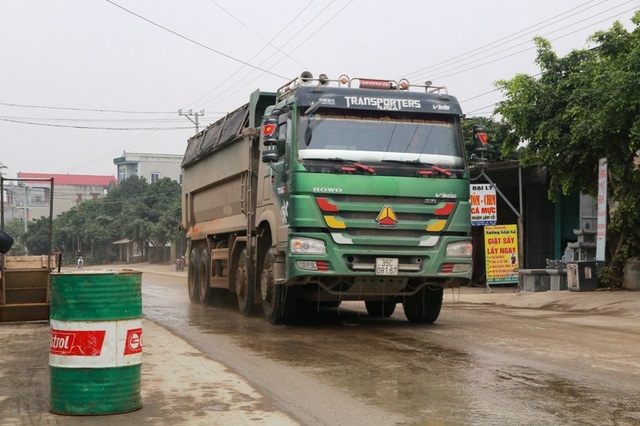 Ninh Bình: Đoàn xe siêu tải “cày ngày cày đêm”, tỉnh lộ căng mình… chống đỡ! - 4 Người dân phải dùng thùng phuy ngăn không cho những chiếc xe siêu tải chạy sát vào nhà mình.