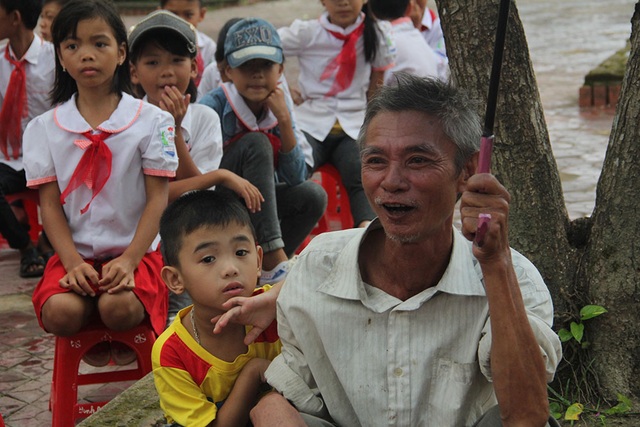 Trẻ em nơi từng trong "tâm bão" háo hức đón Trung thu - 9 Một em bé được ông dẫn vào trường xem chú Cuội, chị Hằng.