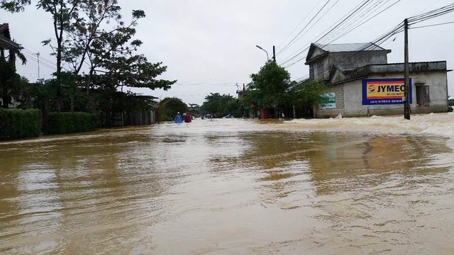 Nước lũ chảy tràn qua đường Nguyễn Chí Thanh dẫn về huyện Quảng Điền