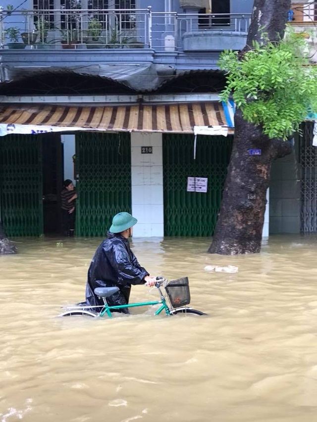 Mưa nguồn vẫn rất lớn – lũ tiếp tục dâng cao "bủa vây" Thừa Thiên Huế - 6 Dắt xe đạp lội gần ngang thắt lưng ở đường Đinh Tiên Hoàng (ảnh: T.Nhân)