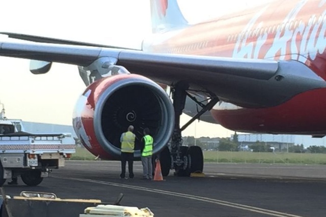 Máy bay AirAsia buộc quay đầu do nghi chim bay vào động cơ - 1 Các nhân viên kỹ thuật đang đánh giá máy bay. (Ảnh: ABC news)