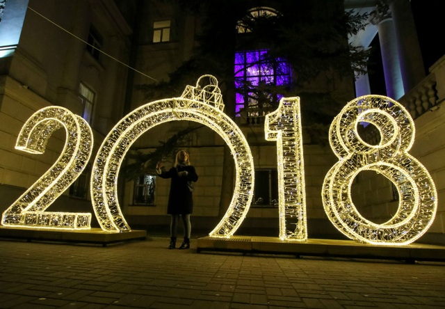 Không khí đón năm mới 2018 rộn ràng khắp thế giới - 9 Một phụ nữ đứng gần khu vực trang trí được thiết kế cách điệu thành số 2018 để chào đón năm mới tại Sevastopol, Crimea - vùng lãnh thổ sáp nhập vào Nga từ năm 2014. (Ảnh: Reuters)