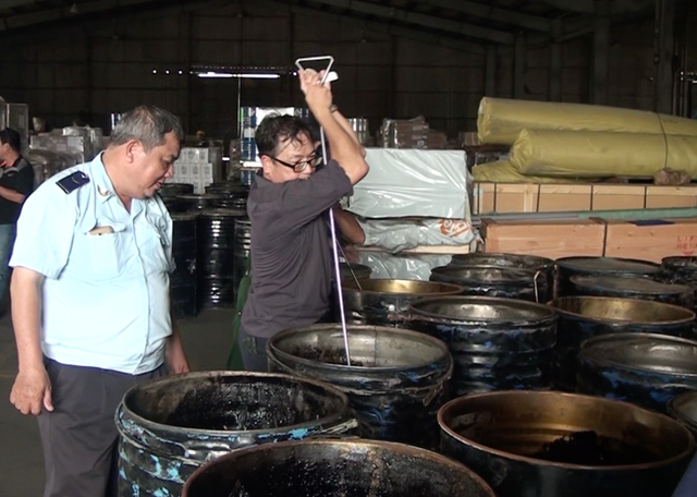 Hơn 1,3 tấn ngà voi trong 14 thùng phuy nhựa đường - 2 Lực lượng chức năng dùng cây xăm để kiểm tra