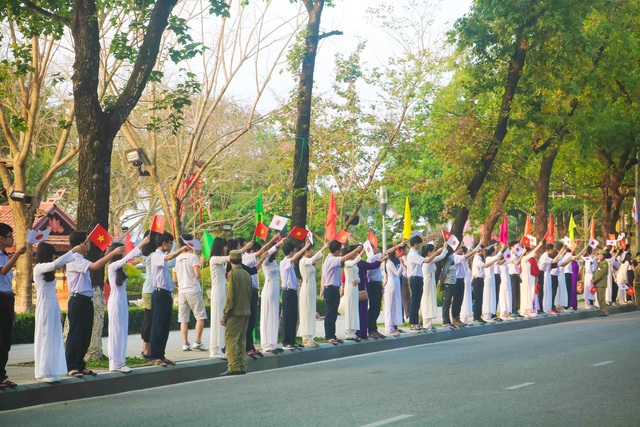 Người dân Cố đô Huế nồng nhiệt đón Nhật hoàng và Hoàng hậu - 3 Trên đường Lê Lợi, các em học sinh tay cầm cờ của hai đất nước Việt Nam và Nhật Bản vui mừng chào đón Nhật Hoàng đến với Cố đô Huế