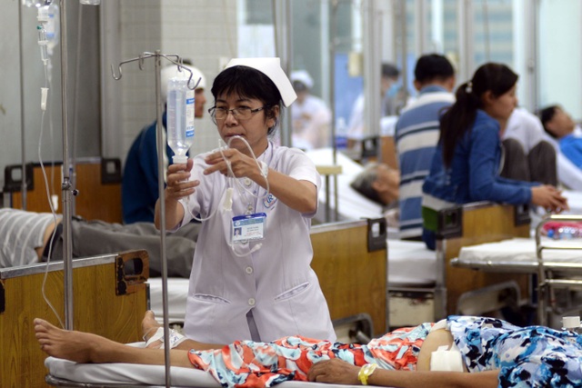 Đêm trực giao thừa của những bác sĩ cấp cứu bệnh viện Chợ Rẫy - 6 Tại khoa cấp cứu, các bác sĩ và điều dưỡng luôn phải túc trực và theo dõi bệnh nhân. Cô Nguyễn Thị Nho, điều dưỡng ở khoa cấp cứu bệnh viện Chợ Rẫy đang truyền thuốc cho nữ bệnh nhân mới được đưa vào cấp cứu.