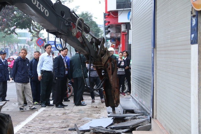 Muôn kiểu "chế" bậc tam cấp trên vỉa hè của người Hà Nội - 9 Nhiều ngày qua lực lượng chức năng quận Đống Đa liên tục ra quân lấy lại vỉa hè cho người đi bộ. Vỉa hè hai bên phố Xã Đàn bị nhiều hộ dân lấn chiếm làm bậc thềm lên xuống nhà đều bị phá bỏ. Căn cứ để phá bỏ thềm nhà lấn chiếm dựa hoàn toàn vào phần diện tích được ghi trong sổ đỏ của từng hộ gia đình.