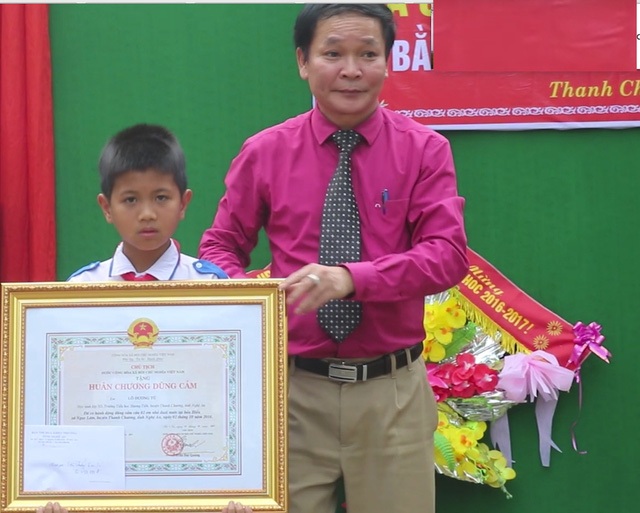Những sự kiện nóng giáo dục tuần qua - 3 Ông Nguyễn Thanh Nhàn - PGĐ Sở Nội vụ - Trưởng ban thi đua khen thưởng tỉnh Nghệ An trao Huân chương dũng cảm cho em Tú.