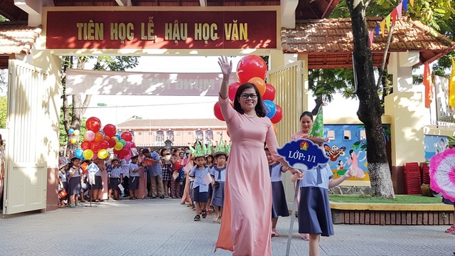 Rộn ràng lễ khai giảng năm học mới trên mọi miền Tổ quốc - 39 Hiệu trưởng Tiểu học Vĩnh Ninh dẫn các em học sinh lớp Một vào trường