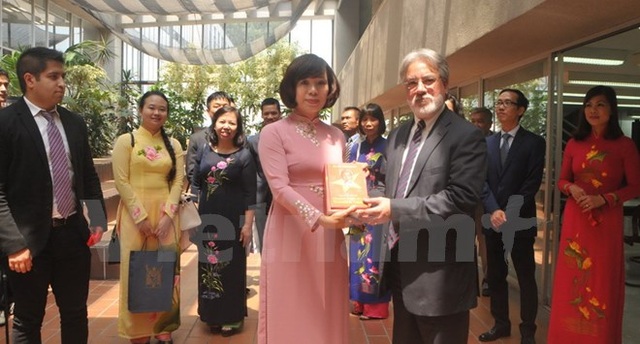 Người Việt tại nước ngoài kỷ niệm 127 năm ngày sinh Chủ tịch Hồ Chí Minh - 8 Đại sứ Lê Linh Lan tặng sách về Bác Hồ cho Chủ nhiệm khoa Kinh tế Eduardo Vega Lopez. (Ảnh: Việt Hùng/Vietnam+)