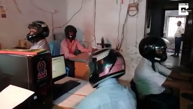 Sợ trần sập, nhân viên văn phòng vừa ngồi làm vừa đội mũ bảo hiểm - 1 Công chức vừa làm việc vừa đội mũ bảo hiểm