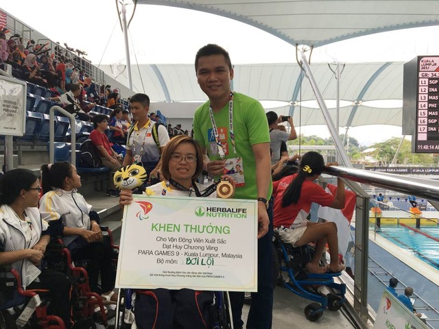 Cuộc sống đời thường của những “người hùng” mang vinh quang về cho đất nước trong Para Games 9 - 1 VĐV bơi lội Vi Thị Hằng khi nhận thưởng nóng từ đại diện Herbalife VN tại Malaysia