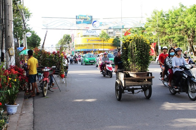 “Chen chân” sắm Tết trong phiên chợ ngày cuối năm - 10 Những ngày này, nghề phu hoa ăn nên làm ra nhờ chở hoa cho các gia chủ. Không thưa vắng như vài hôm trước, chiều 29 và 30 Tết cảnh chở xuân về nhà bắt đầu xuất hiện đều đặn trên phố