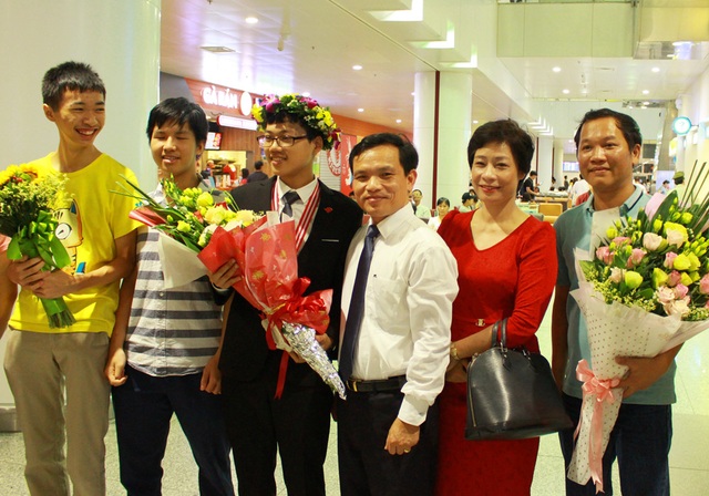 “Cậu Vàng” Đinh Anh Dũng: Đam mê là bí quyết thành công - 3 Đinh Anh Dũng trong vòng tay đón chào của thầy cô, bạn bè tại sân bay Nội Bài tối 24/7.
