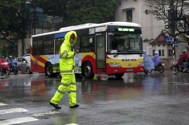 Cảnh sát giao thông thường xuyên phải dầm mưa để điều khiển giao thông tại những vị trí trọng yếu, dễ ùn tắc.