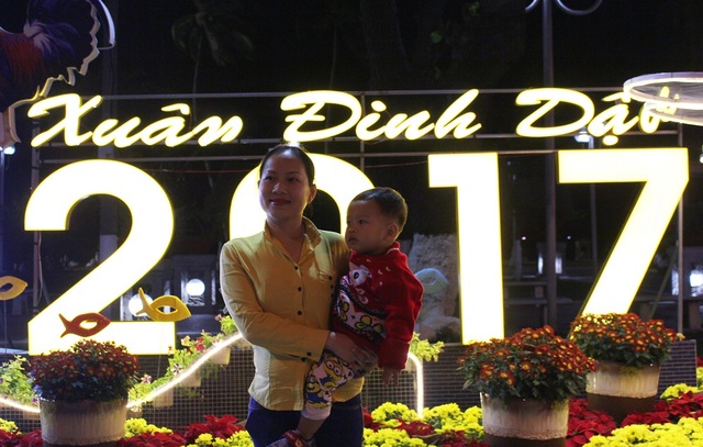 Người dân cả nước hân hoan trong phút giao thừa - 56 Người phụ nữ bế con lưu lại kỷ niệm ở một điểm trang trí Tết trên đường Trần Phú trước thời khắc đón năm mới Đinh Dậu - Ảnh: Viết Hảo