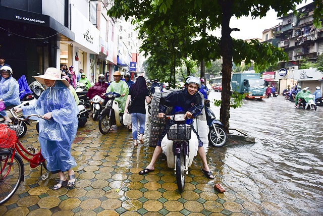 Mưa hơn một giờ, phố lớn Hà Nội lại thành sông - 6
Nhiều người chọn cách đi lên vỉa hè để qua được đoạn ngập.