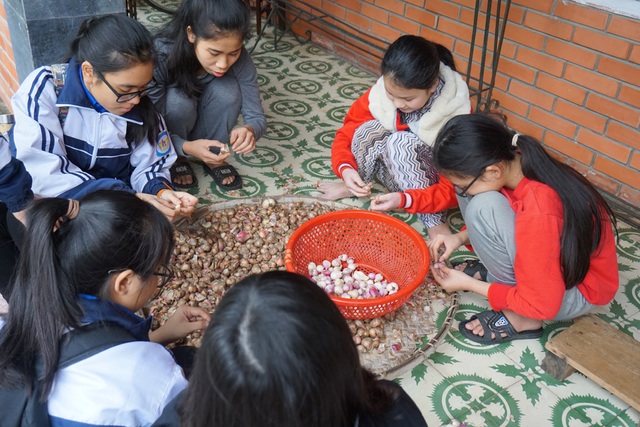 Tết ấm áp ở Làng trẻ em SOS - 5 Các em nhỏ cùng các tình nguyện viên bóc hành chuẩn bị nhân gói bánh chưng.