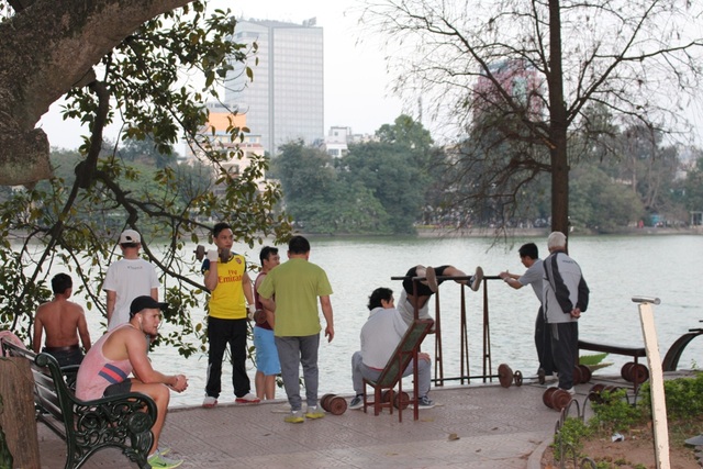Muôn kiểu tập thể dục của người Hà Nội - 5 Hàng ngày, cứ vào đầu giờ sáng hoặc cuối giờ chiều, “phòng thể hình” ngoài trời lại trở thành điểm đến của nhiều người. Phòng tập này chiếm một diện tích nhỏ tại đường ven Hồ Gươm (phía đường Lê Thái Tổ, quận Hoàn Kiếm, Hà Nội)