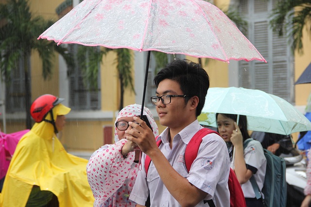 TPHCM: Thí sinh lại đội mưa về sau buổi thi môn Ngoại ngữ - 3 Dưới cơn mưa, nhiều thí sinh gương mặt hớn hở chấp nhận ướt mưa về nhà.