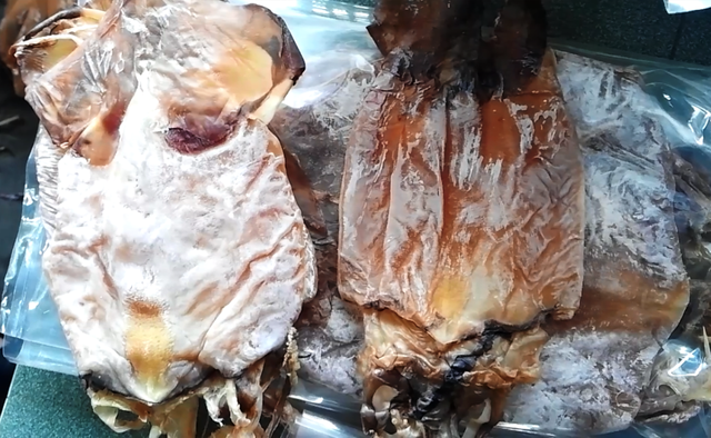 Con mực xà (trái) trắng nhìn bắt mắt sau khi lột lớp lụa bên ngoài màu đen (con bên phải). Ảnh: Doãn Công