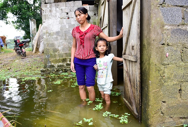 Gà vẫn ở trong nhà dân ngoại thành Hà Nội sau một tuần ngập lũ - 10
Về thăm nhà, hai mẹ con chị Sơn ngán ngẩm đứng nhìn nước ngập.