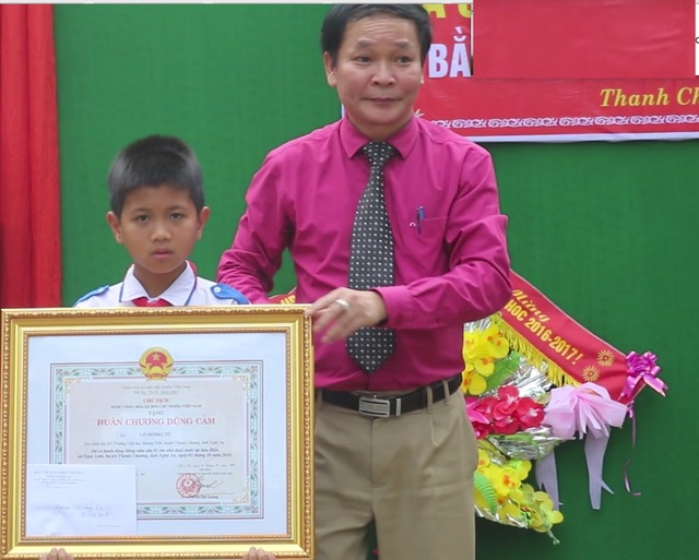 Trao Huân chương của Chủ tịch nước đến học sinh lớp 5 cứu hai em nhỏ khỏi đuối nước - 1 Ông Nguyễn Thanh Nhàn - PGĐ Sở Nội vụ - Trưởng ban thi đua khen thưởng tỉnh Nghệ An trao Huân chương dũng cảm cho em Tú.