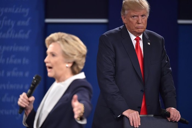 Đường tới Nhà Trắng của tỷ phú Donald Trump - 24 Ngày 8/10/2016, 1 tháng trước khi diễn ra cuộc bỏ phiếu chính thức trên cả nước, tỷ phú Trump bất ngờ gặp sóng gió liên quan đến đoạn video bị rò rỉ, trong đó ứng viên tổng thống đảng Cộng hòa bị ghi âm những lời lẽ thô tục về việc sàm sỡ phụ nữ. Vụ lùm xùm này đã khiến dư luận Mỹ tranh cãi trong nhiều ngày và ông Trump phải đối mặt với không ít lời chỉ trích, trong đó có đối thủ Clinton, khi chiến dịch tranh cử đang bước vào giai đoạn nước rút. Trong ảnh: Bà Clinton chỉ trích ông Trump vì những bình luận khiếm nhã với phụ nữ trong cuộc tranh luận lần 2 ngày 9/10 tại Đại học Washington, bang Missouri, Mỹ. (Ảnh: AFP)