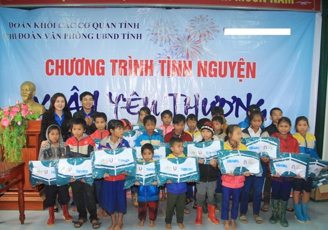 Các cán bộ Đoàn tặng áo ấm cho các em học sinh.