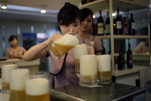 Nhà máy bia Taedonggang đã nghiên cứu và cho ra mắt loại bia mới vào ngày 26/7 vừa qua, tuy nhiên loại bia này vẫn chưa được đóng chai và chưa có tên chính thức. Loại bia mới nhất của Triều Tiên được cho là không có vị đắng và có mùi bạc hà. Trong ảnh: Một nữ nhân viên rót loại bia mới được làm từ lúa mì và cây hoa bia của nhà máy Taedonggang.