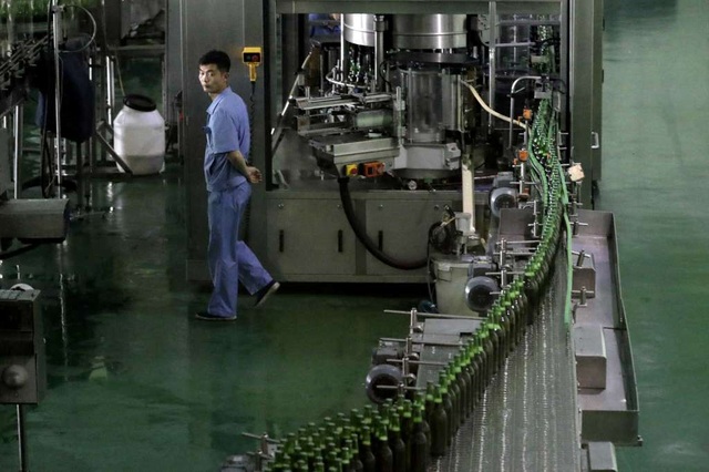 Bên trong nhà máy bia nổi tiếng tại Triều Tiên - 4 Han Hyong Chol, người phụ trách quản lý chất lượng của nhà máy bia Taedonggang, cho biết mỗi ngày nhà máy bia Taedonggang sản xuất khoảng 200.000 lít bia để đáp ứng nhu cầu của người tiêu thụ bia ở thủ đô Bình Nhưỡng - thành phố 3 triệu dân với khoảng 160 quán bia. Trong ảnh: Công nhân giám sát dây chuyền sản xuất bia tại nhà máy Taedonggang.