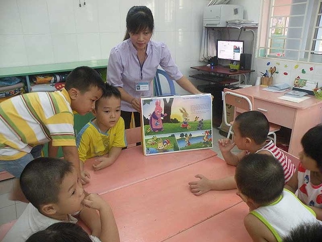 Làm thế nào để đáp ứng nhu cầu gửi con của công nhân? - 2 Cô và trò đọc truyện tranh trong giờ giữ ngoài giờ tại Trường Mầm non 30-4 (KCN Vĩnh Lộc, quận Bình Tân, TPHCM). (Ảnh: Báo Pháp luật TPHCM)