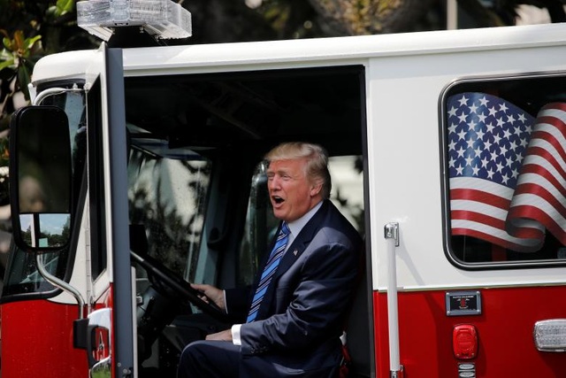Tổng thống Trump đích thân quảng cáo hàng hóa của Mỹ - 3 Tổng thống Trump cam kết sẽ đưa ra các điều chỉnh về pháp lý trong vòng 6 tháng tới để bảo vệ các doanh nghiệp sản xuất của Mỹ và xóa bỏ các rào cản thương mại cản trở hoạt động của các doanh nghiệp. Trong ảnh: Ông Trump ngồi trong một xe tải do Mỹ sản xuất sử dụng cho mục đích cứu hỏa được trưng bày tại buổi triển lãm ở Nhà Trắng.