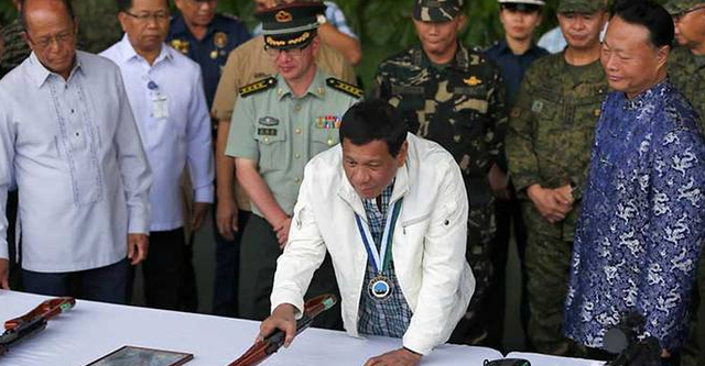 Trung Quốc tặng hàng nghìn khẩu súng cho Philippines - 1 Tổng thống Rodrigo Duterte (áo trắng) kiểm tra số vũ khí do Trung Quốc trao tặng. Đứng cạnh ông là Đại sứ Trung Quốc tại Philippines Triệu Giám Hoa (phải) (Ảnh: AFP)