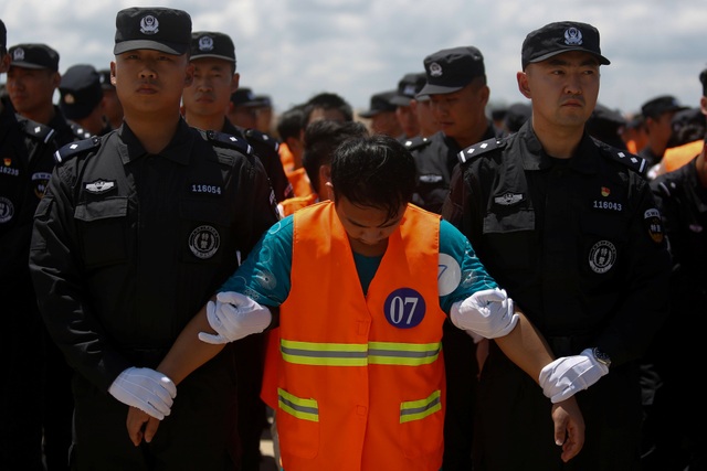 Các nghi phạm Trung Quốc bị đưa ra sân bay Phnom Penh để trục xuất về nước ngày 12/10 (Ảnh: Reuters)