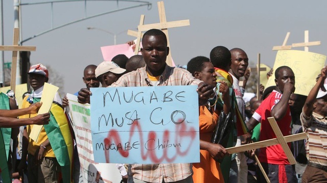 Nhìn lại 37 năm cầm quyền của Tổng thống Zimbabwe Mugabe - 14
Đảng cầm quyền ZANU-PF của ông chiến thắng trong cuộc tổng tuyển cử năm 2013 sau 4 năm tồn tại của một chính phủ chia sẻ quyền lực. Các chính sách của đảng này đã dẫn đến tình trạng khan hiếm tiền mặt trầm trọng ở Zimbabwe và kéo theo các cuộc biểu tình phản đối chính phủ. (Ảnh: AFP)