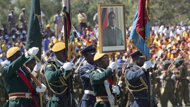 Nhìn lại 37 năm cầm quyền của Tổng thống Zimbabwe Mugabe - 15
Tuy nhiên, lực lượng an ninh vẫn trung thành tuyệt đối với ông Mugabe cho tới khi bà Grace lộ rõ tham vọng quyền lực, muốn kế nhiệm chồng trong cuộc bầu cử vào năm sau. Tham vọng này đã khiến quân đội dưới sự chi phối của cựu Phó Tổng thống tiến hành một cuộc chính biến gây sức ép buộc nhà Mugabe từ bỏ quyền lực. (Ảnh: AFP)
