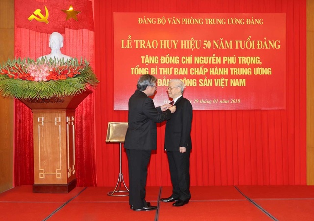 Tổng Bí thư Nguyễn Phú Trọng nhận Huy hiệu 50 năm tuổi Đảng - 1
Đồng chí Trần Quốc Vượng, Ủy viên Bộ Chính trị, Thành viên Thường trực Ban Bí thư, Chủ nhiệm Ủy ban Kiểm tra Trung ương gắn Huy hiệu 50 năm tuổi Đảng tặng đồng chí Nguyễn Phú Trọng, Tổng Bí thư Ban Chấp hành Trung ương Đảng Cộng sản Việt Nam. Ảnh: Trí Dũng – TTXVN