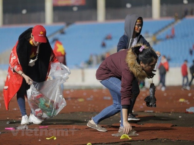 
Cổ động viên ở lại nhặt rác sau khi xem trận chung kết giải U23 châu Á 2018 ở sân vận động Mỹ Đình (Hà Nội). (Ảnh: Vietnamplus)
