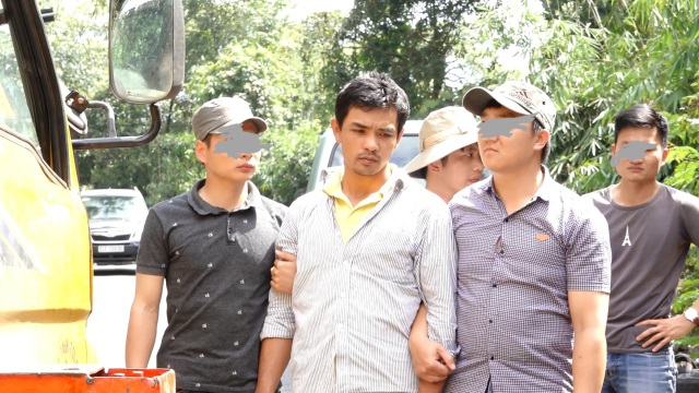 Vụ giết chủ nợ phi tang xác trong vườn cà phê: Khởi tố bị can tội giết người, cướp tài sản - 1 Đối tượng Vũ (áo trắng) bị dẫn giải đến hiện trường vụ án