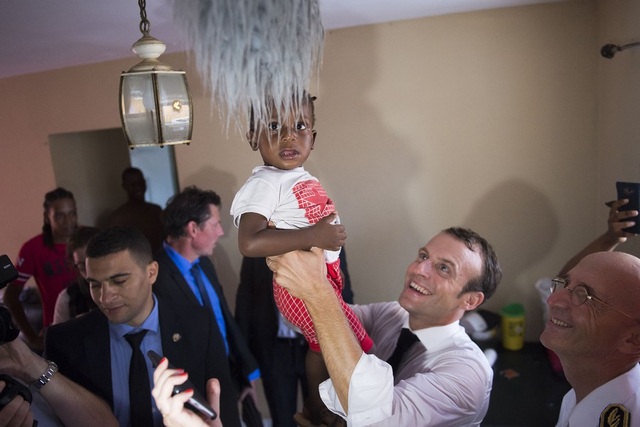 Bức ảnh gây tranh cãi của tổng thống Pháp khi thăm vùng bão - 2 Tổng thống Macron bế một em nhỏ khi tới thăm các gia đình tại Saint Martin sau bão Irma (Ảnh: RT)
